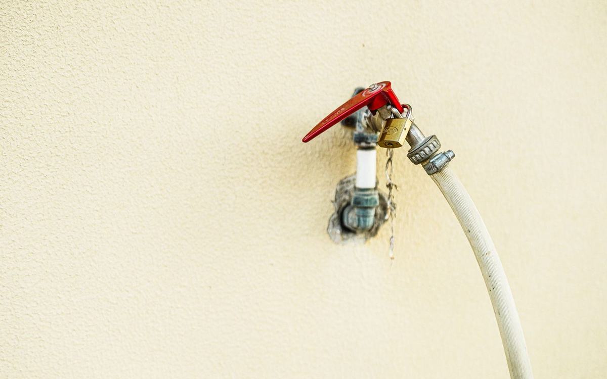 Outside wall tap with a garden hose connected